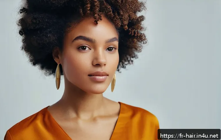 블랙헤어를 위한 스타일링 팁 - A close-up portrait of a young Black woman with natural, tightly coiled afro-textured hair styled in...
